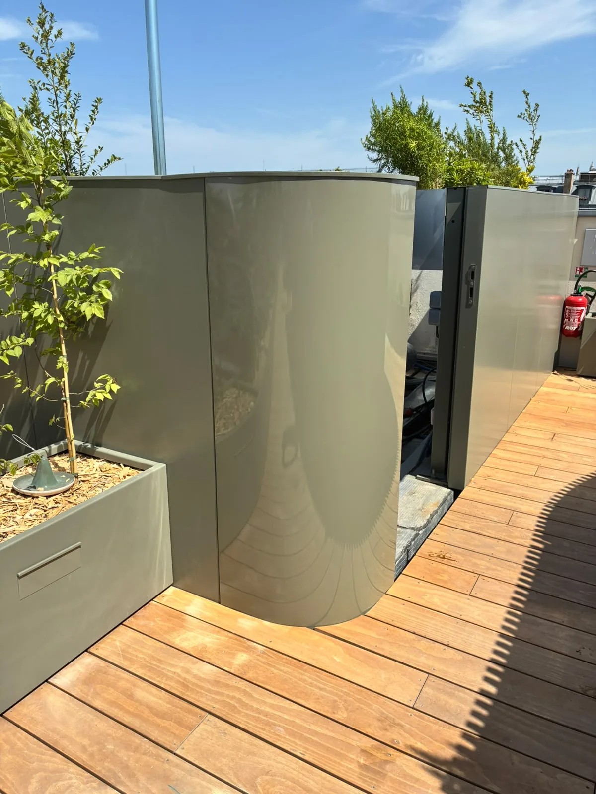 Panneaux d'habillage métalliques déformés sur la terrasse d'un rooftop parisien