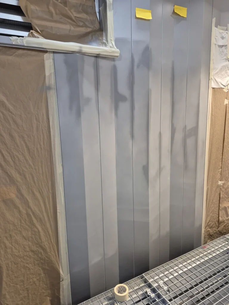 Tôle de bardage intérieur masquée au papier kraft, apprêt appliqué sur plusieurs nervures autour des points repris